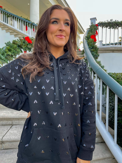 The Jenny Sequin Hoodie from Shop Silvs is a black hoodie with a front pocket and subtle sequin design.