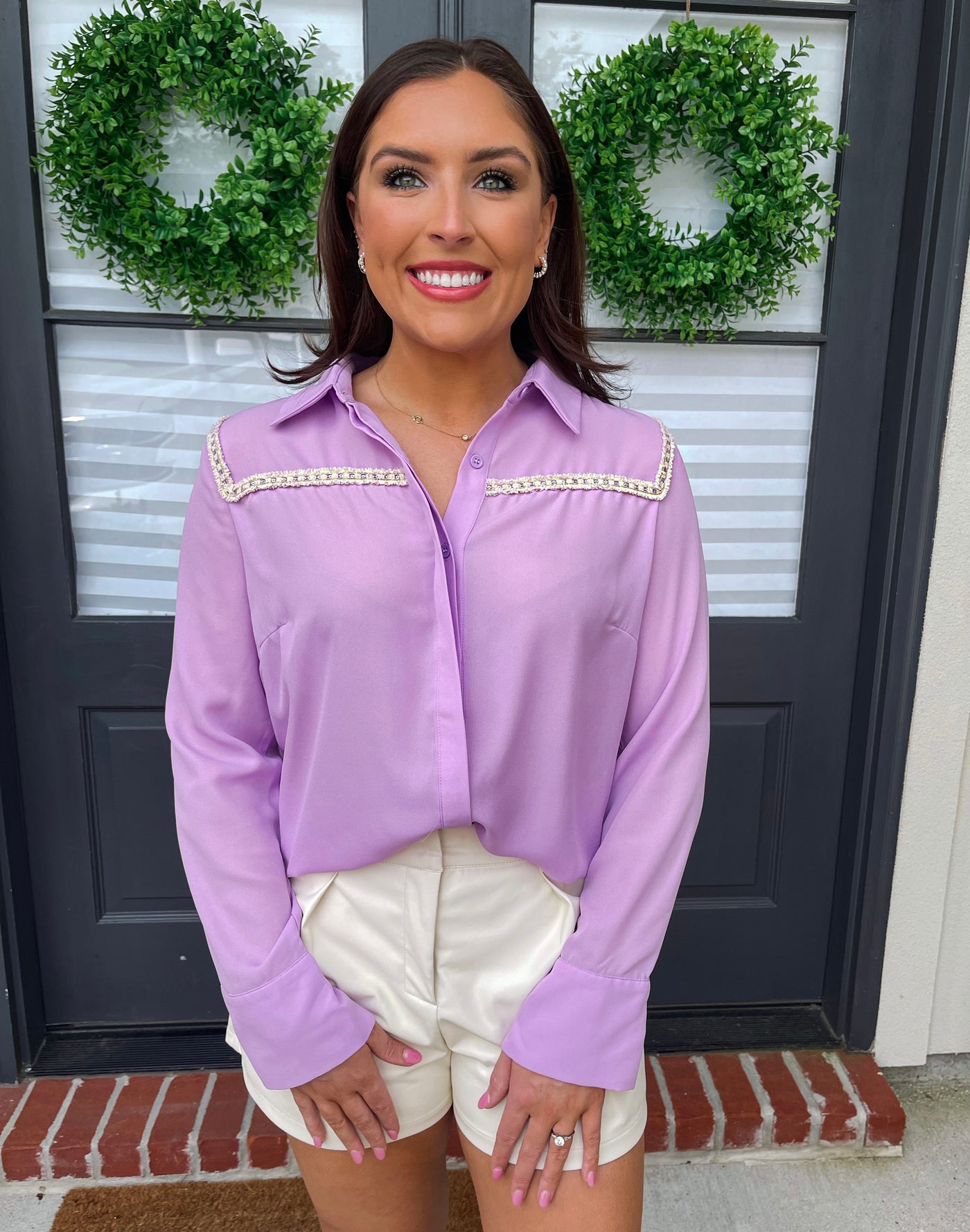 Pair this purple v-neck button down shirt with cream leather shorts.