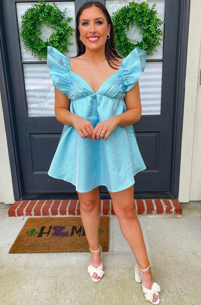 This BuddyLove blue ruffle mini dress with pockets pairs well with white heels.