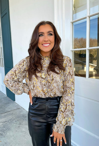 The Lorrie Top from Shop Silvs is a gold blouse with smocked cuffs that looks great dressed up or down.