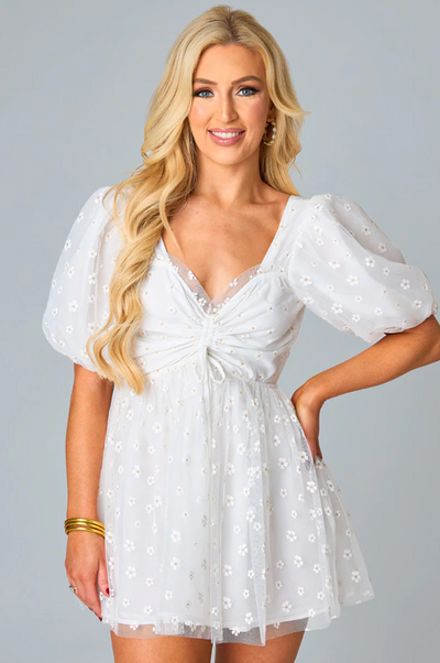 The Daisy Dress from Shop Silvs is an adorable knee-length white dress featuring puff sleeves and a cutout in the back.