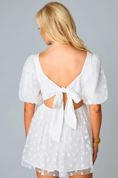 This white puff sleeve dress features an adorable back cutout and bow tie detailing.