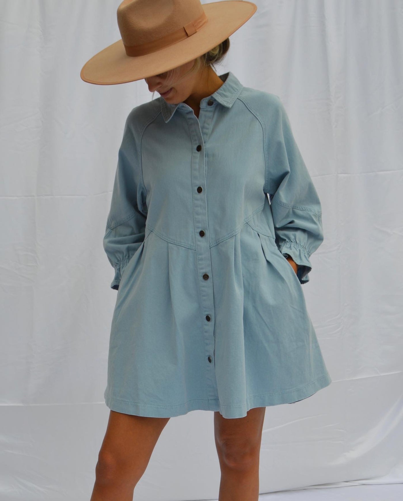 Our button up denim babydoll dress features a light denim wash.