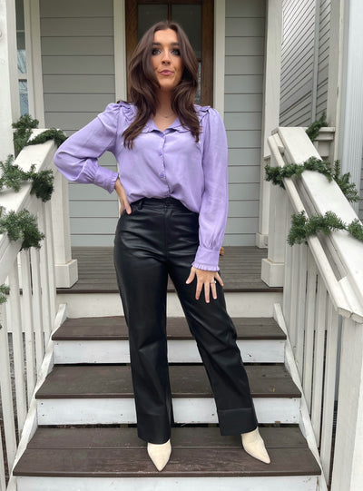 Pair this purple ruffle collar button up top with black leather pants for a classy workwear look. 