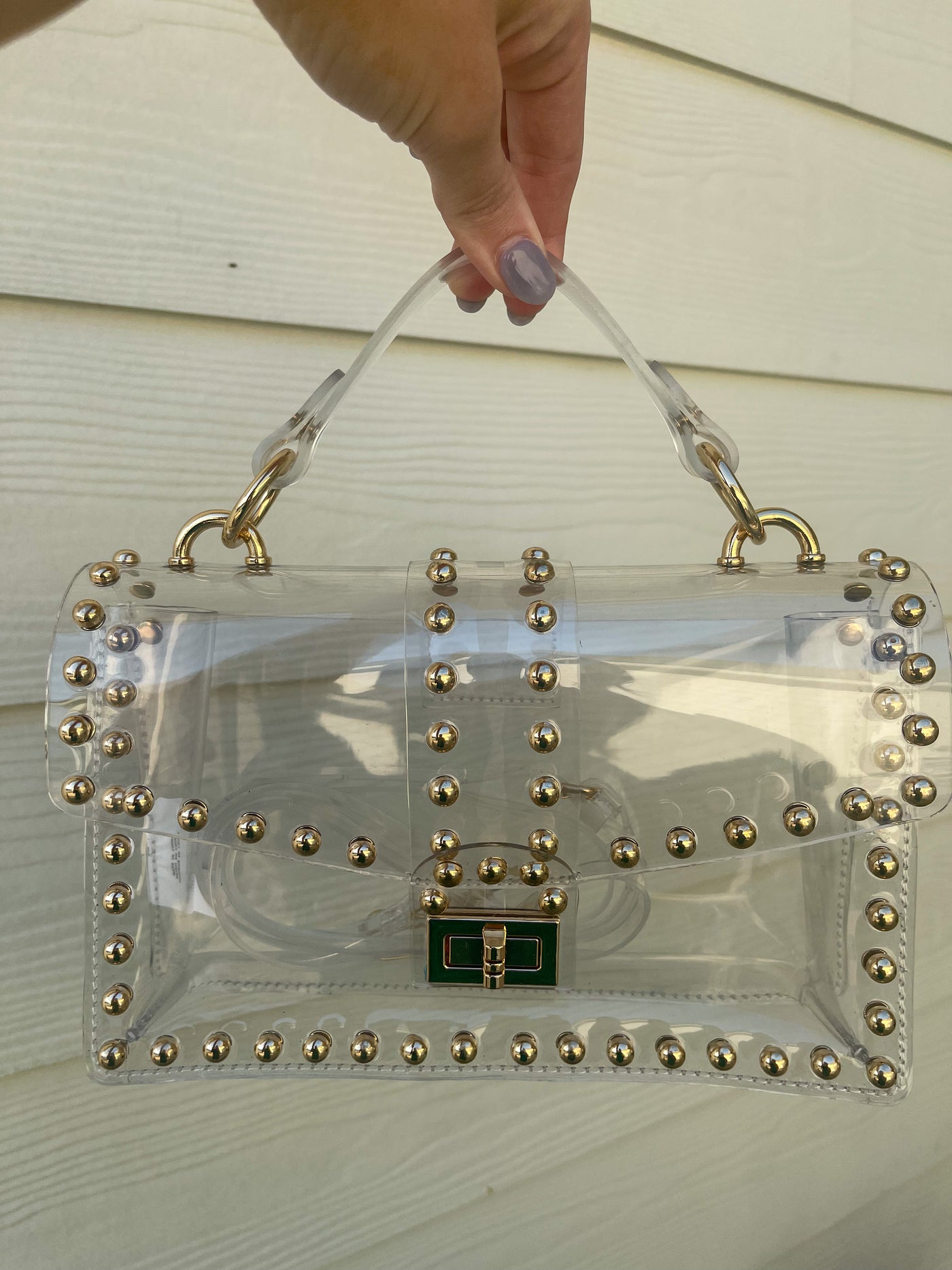 Keep at simple and fashionable on game day with this clear gold studded bag.