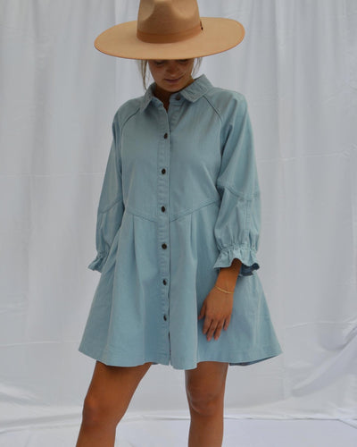 Pair this button up denim babydoll dress with a wide-brimmed hat.