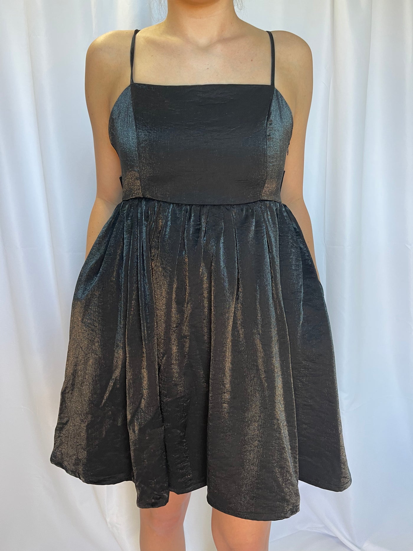 The Baby Doll Bow Dress from Shop Silvs is a black satin baby doll dress.