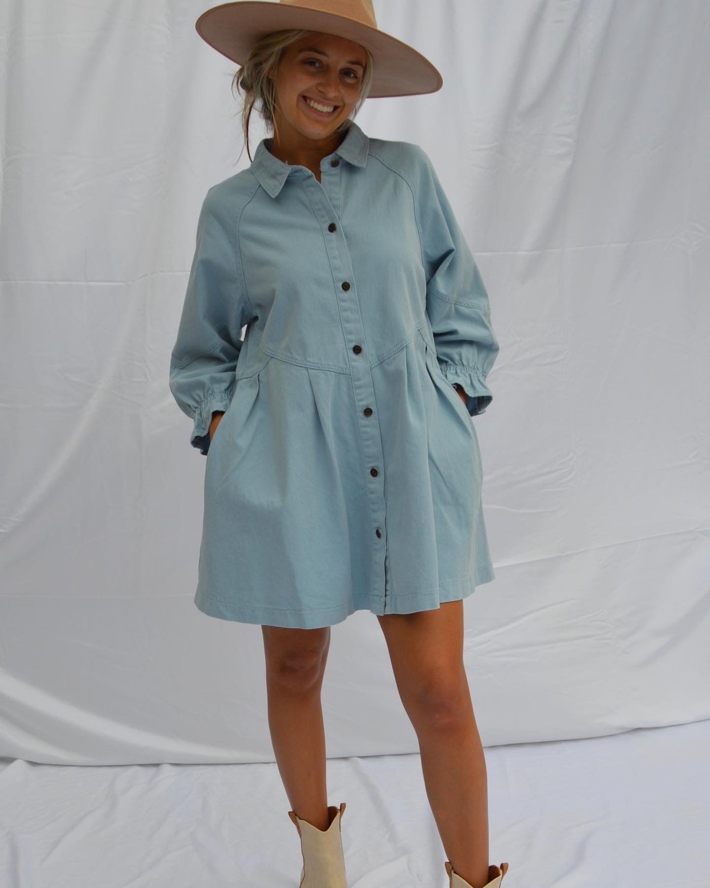 The Denim Babydoll Dress from Shop Silvs features a collared neckline and ruffles at the wrists. 